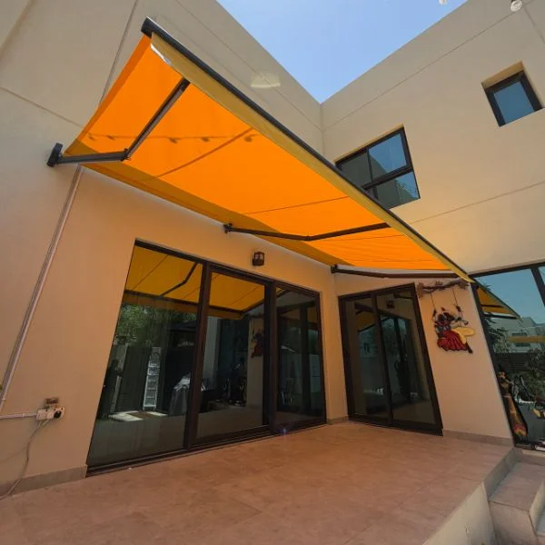 Orange retractable awning shading an outdoor terrace